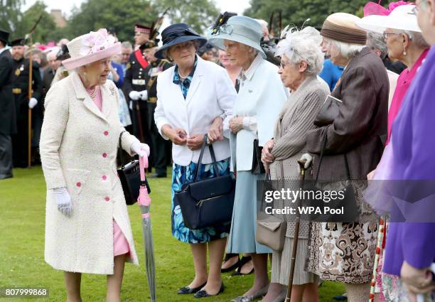 Queen Elizabeth II meets members of the Glasgow Wrens Association during the annual garden party at the Palace of Holyroodhouse on July 4, 2017 in...