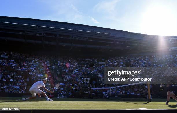 Austria's Dominic Thiem returns against Canada's Vasek Pospisil during their men's singles first round match on the second day of the 2017 Wimbledon...