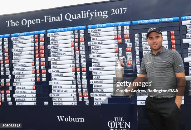 Toby Tree of England poses next to the claret jug after securing one of the three qualifying positions during The Open Championship Final Qualifying...