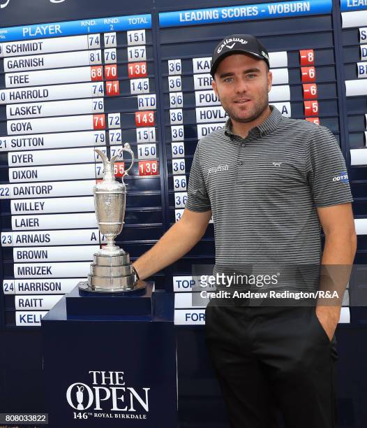 Toby Tree of England poses next to the claret jug after securing one of the three qualifying positions during The Open Championship Final Qualifying...