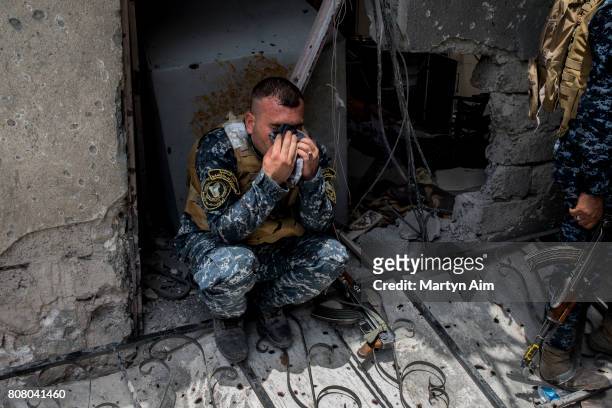 An Iraqi Federal Police soldier rests after pulling back to his position after a grenade attack by Islamic State militants in the Old City district...