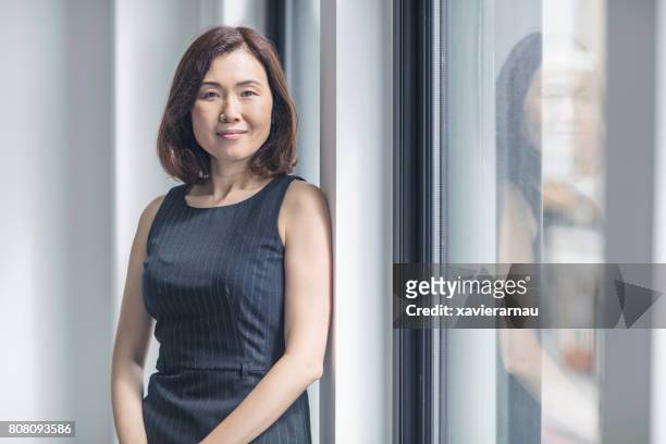 porträt von zuversichtlich geschäftsfrau im büro - mature women portrait asian stock-fotos und bilder