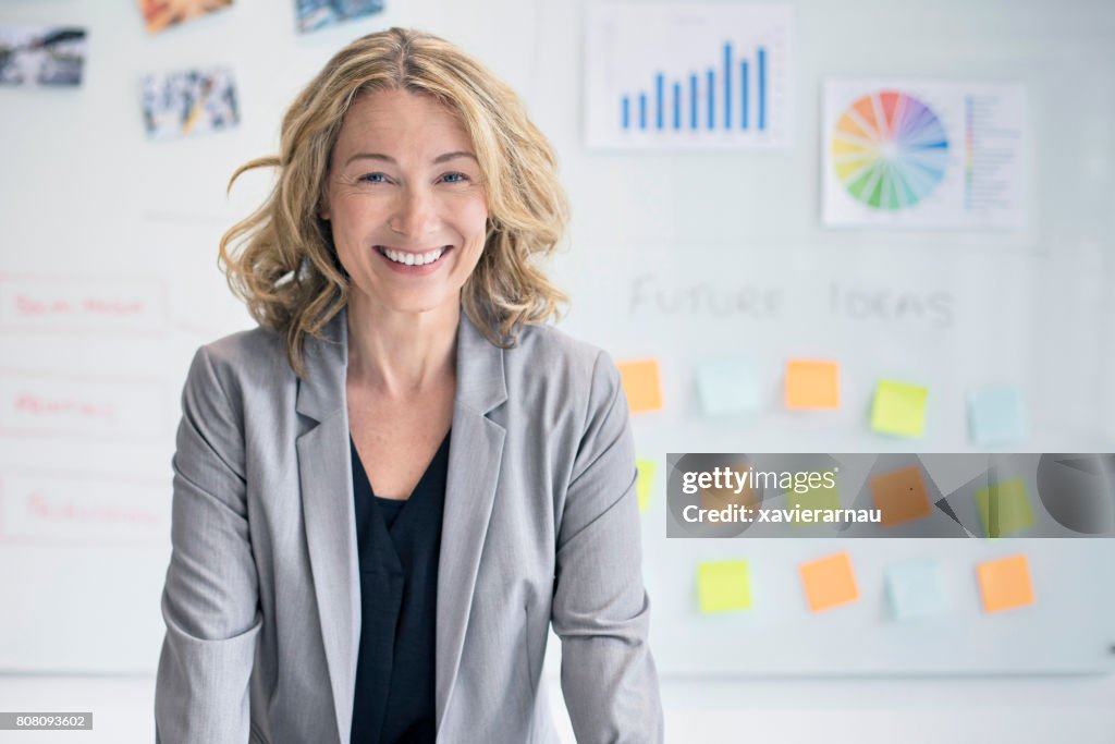 Confident businesswoman against whiteboard