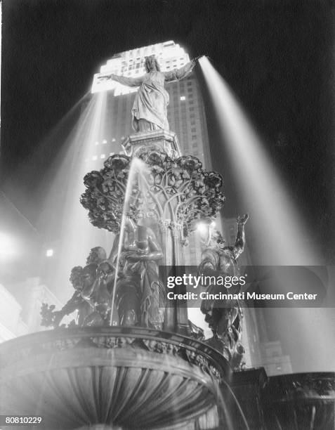 View of 'The Genius of Water' illuminated against the backdrop of the art deco Carew Tower in Fountain Square, Cincinnati, Ohio, 1940s. The fountain...