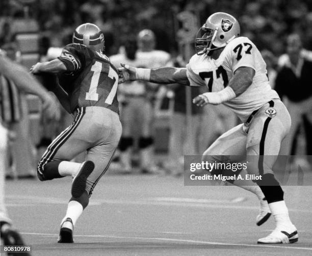 Seattle Seahawks quarterback Dave Krieg tries to avoid being tackled by Los Angeles Raiders end Lyle Alzado in a 13-7 win over the Los Angeles...