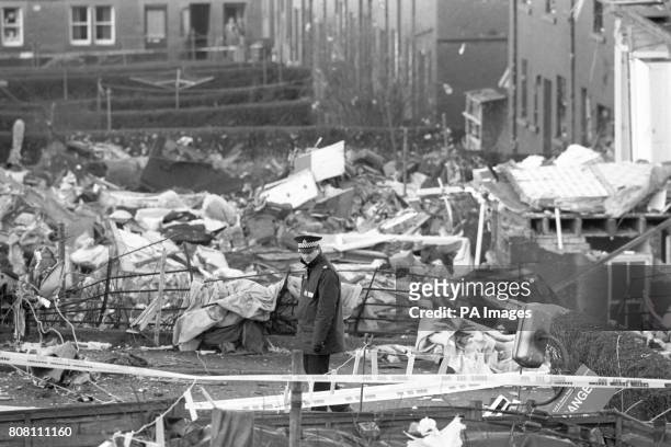 Policeman stands guard over houses damaged in the Pan Am Boeing 747 Lockerbie bombing crash, which killed all 259 on board and 11 people on the...
