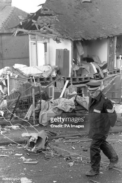 Police officer stands guard over houses wrecked in the Pan Am Boeing 747 Lockerbie bombing and crash, which killed all 259 on board and 11 people on...