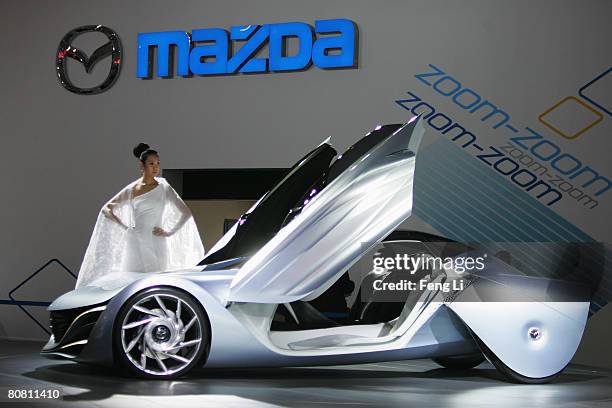 Model poses beside the Mazda concept car Taiki during a special media opening of the Auto China 2008 show at the new China International Exhibition...