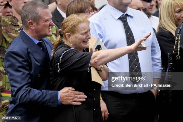 Trooper James Leverett's grandmother Linda Mason , holds a photo of her grandson and calls out his name as she waves him goodbye as his coffin passes...