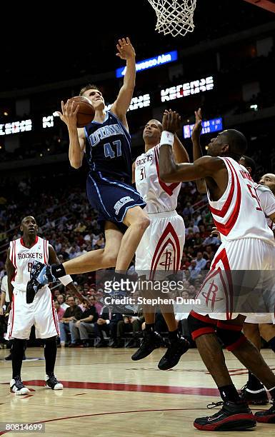 Andrei Kirilenko of the Utah Jazz goes up for a shot against Shane Battier and Dikembe Motumbo of the Houston Rockets in Game Two of the Western...