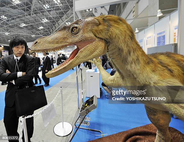Robotic Velociraptor dinosaur opens its mouth to scare visitors as it demonstrates the power of air pressure at the fluid power exhibition in Tokyo...