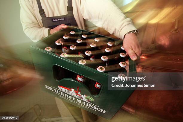 Worker carries a beer crate in front of a mash tank at the Maisacher brewery, on April 22, 2008 in Maisach near Munich, Germany. Beer is regarded as...