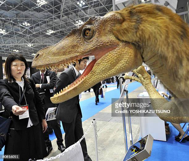 Robotic Velociraptor dinosaur opens its mouth to scare visitors as it demonstrates the power of air pressure at the fluid power exhibition in Tokyo...