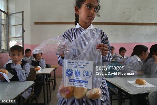Palestinian schoolgirl distributes vitamin-enriched snacks provided daily by the World Food Program to her classmates April 21, 2008 in the West Bank...