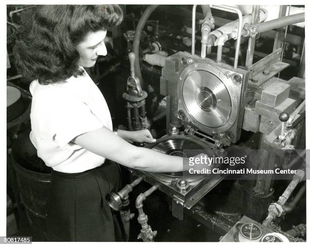 High-angle view of an unidentified woman as she lifts a copy of the Leon Rusk record 'Air Mail Special on the Fly' from a stamper at the King Record...