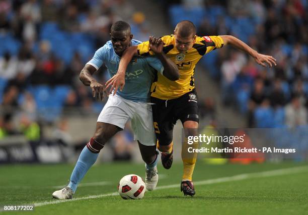 Manchester City's Micah Richards and FC Timisoara's Alexandru Bourceanu battle for the ball.
