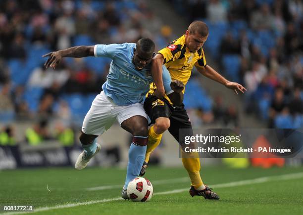 Manchester City's Micah Richards is challenged by FC Timisoara's Alexandru Bourceanu .