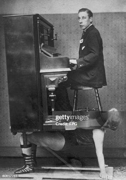 Circus strongwoman balances a piano and pianist on her chest, circa 1920.