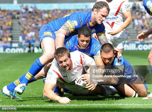 St Helens' Bryn Hargreaves is held back from scoring a try by Leeds Rhinos' Jamie Peacock , Brent Webb and Kevin Sinfield during the Carnegie...