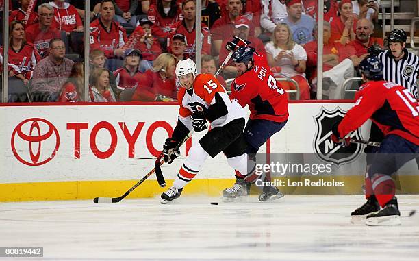 Joffrey Lupul of the Philadelphia Flyers scraps for the puck against Tom Poti of the Washington Capitals during game five of the Eastern Conference...