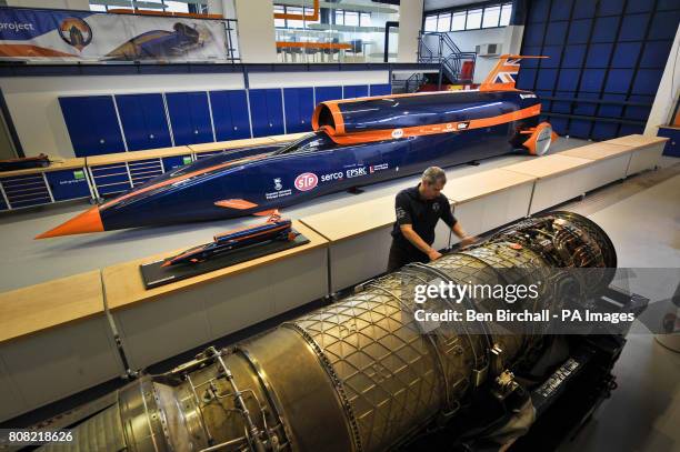 Chief Engineer Mark Chapman inspects a Euro Jet EJ 200 Typhoon jet engine next to a 1:1 scale model of the Bloodhound supersonic car, at the...