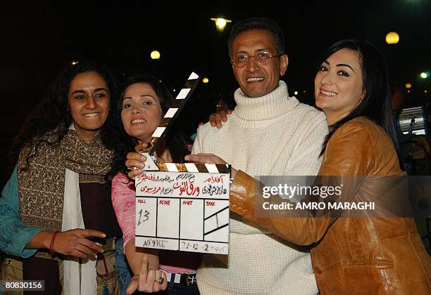 Egyptian director Amr Bayumi poses with three young actresses taking part in his new film 'Waraq Al-Tout' during a shooting session in Cairo late 21...