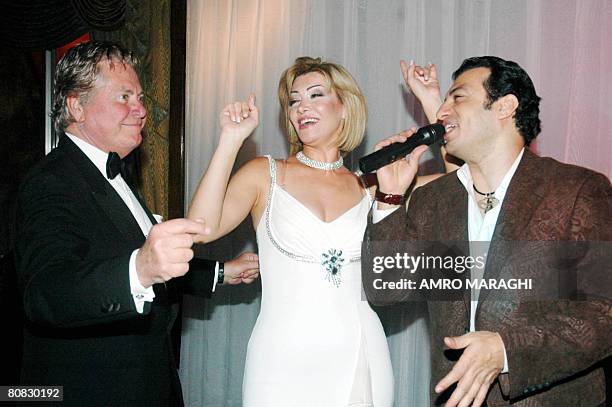 Egyptian actor Hussein Fahmi and his bride Egyptian actress Liqa Sweidan dance as Egyptian singer Ihab Tawfiq sings during their wedding ceremony in...