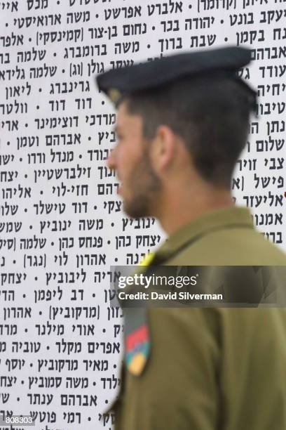 An Israeli soldier passes the Wall of Names of fallen soldiers at the Armoured Corps Memorial April 25, 2001 at Latrun in central Israel during a...