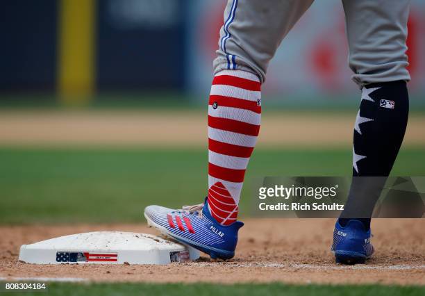 Kevin Pillar of the Toronto Blue Jays stands on first base with special socks and shoes for celebrating Independence Day during a game against the...
