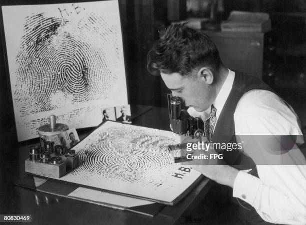 Fingerprint expert Captain Howard L. Barlow of the Los Angeles Police Department, examines a fingerprint, enlarged 500 times, circa 1925. Barlow...