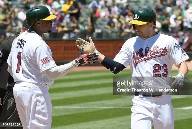 Matt Joyce of the Oakland Athletics is congratulated by Rajai Davis after Joyce hit a two-run homer against the Chicago White Sox in the bottom of...