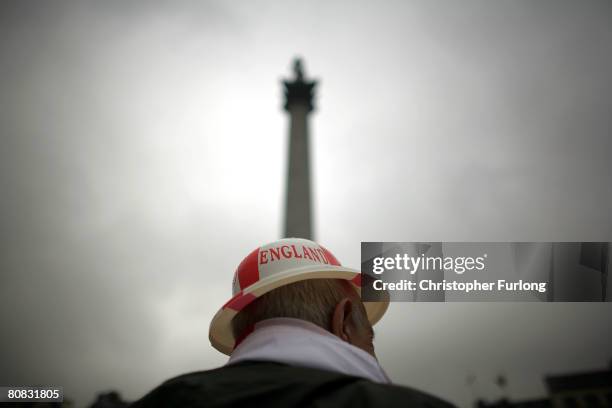 Patriotic pensioner Jim Diper braves the rain to don his plastic England bowler hat and join the festivities below Nelson's Column celebrating Saint...