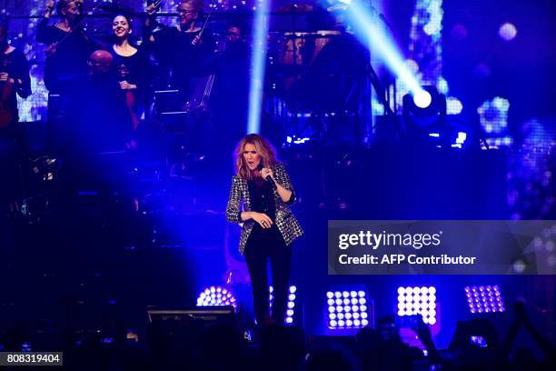 Canadian singer Celine Dion performs on the stage of the AccorHotels Arena in Paris on July 4, 2017. / AFP PHOTO / Martin BUREAU