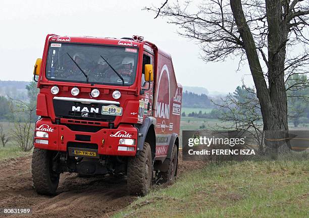 Dutch truck drivers Hans Stacey, Charly Gotlib and Bern Der Kinderen steer their Man on a muddy road during the fourth stage of the Central European...