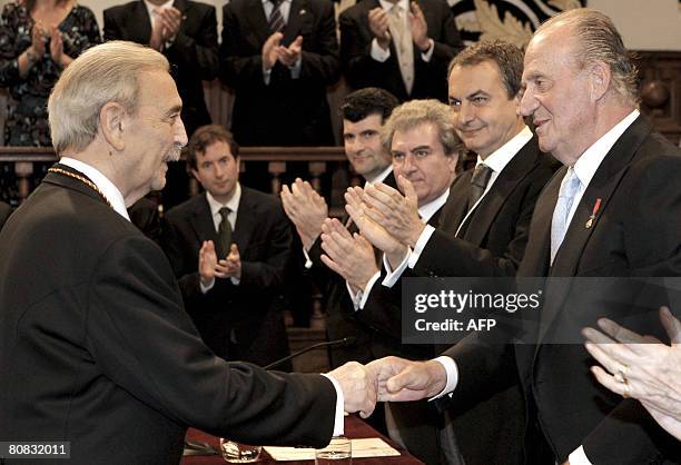 Spain's King Juan Carlos shakes hands with Argentinian poet Juan Gelman after awarding him the Cervantes literature prize, the equivalent of a nobel...