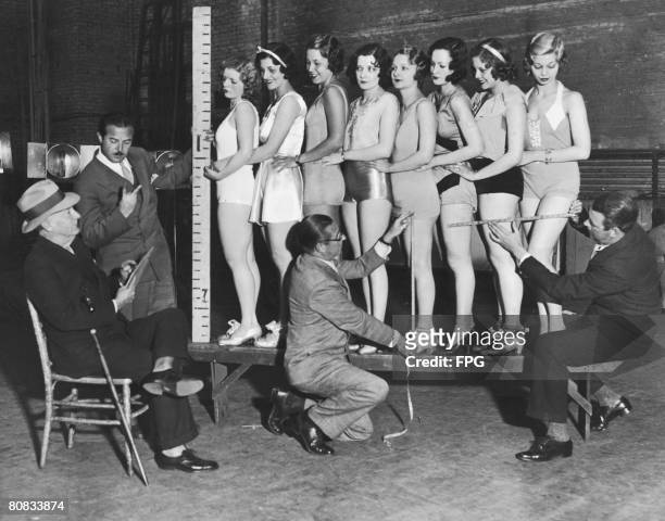 Participants in a beauty contest are measured by a team of experts, circa 1935.
