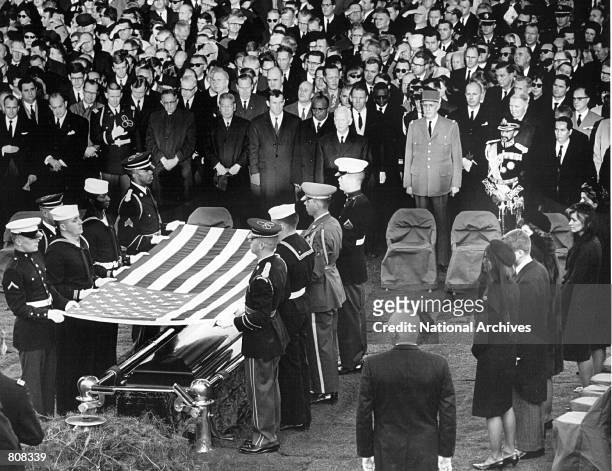 Honor guard place a flag over the casket of President John F. Kennedy during his funeral service November 25, 1963 in Arlington Cemetery.