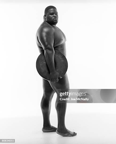 Record-holding super-heavyweight weightlifter, Mark Henry, in June of 1996 holds a large weight to cover himself at a training facility in Atlanta,...