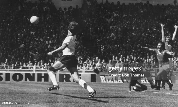 The ball is on the way into the Liverpool goal as Manchester United's Lou Macari celebrates after his shot had struck his team-mate Jimmy Greenhoff,...