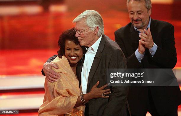 German actor Karlheinz Boehm is hugged by his wife Almaz as actor Wolfgang Stumph looks on during the TV-show "Congratulations Karlheinz Boehm - A...