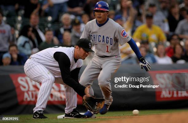 Kosuke Fukudome of the Chicago Cubs slides safely in to third with a second inning triple as Garrett Atkins of the Colorado Rockies takes a late...