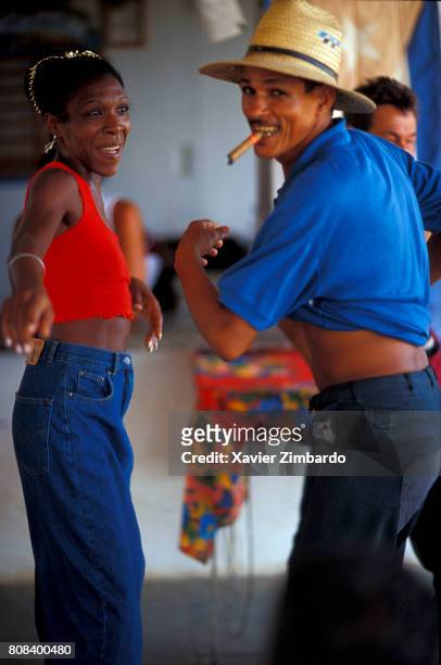 Peasant smoking a cigar is dancing with a smiling woman during a popular festival on May 17, 2001 at Trinidad, Cuba. The Day of the Peasant is...