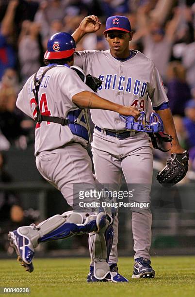 Pitcher Carlos Marmol and catcher Henry Blanco of the Chicago Cubs celebrate after they defeated the Colorado Rockies at Coors Field on April 23,...