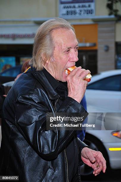 Actor David Carradine eats a hot dog at the world premiere of the movie "Polanski Unauthorized", held at the Westwood Majestic Crest Theater on April...