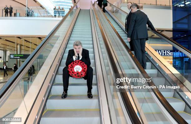 Ryanair CEO Michael O'Leary travels down an escalator holding a wreath in Dublin Airport's Terminal 2, after it was officially opened today.