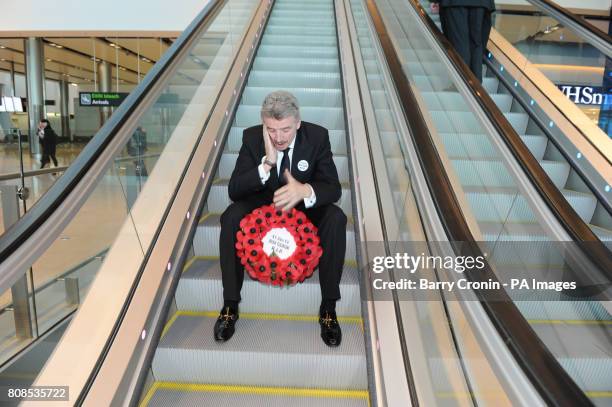 Ryanair CEO Michael O'Leary travels down an escalator holding a wreath in Dublin Airport's Terminal 2, after it was officially opened today.