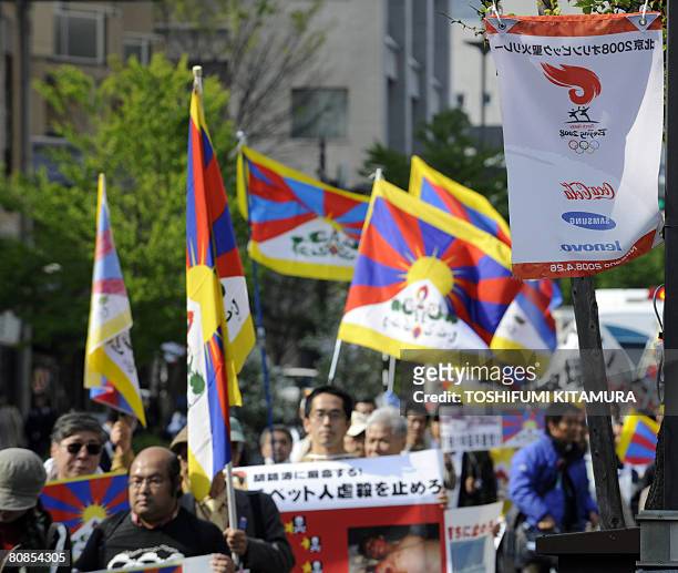Poster featuring Beijing Olympic torch relay is displayed in central Nagano city as pro-Tibet demonstrators stage a protest march on April 25, 2008 a...