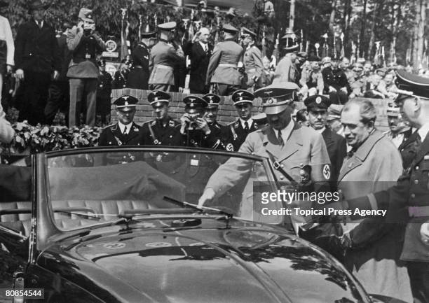 German Chancellor Adolf Hitler inspects the new, Volkswagen 'people's car' after laying the foundation stone of the new Volkswagen works at...