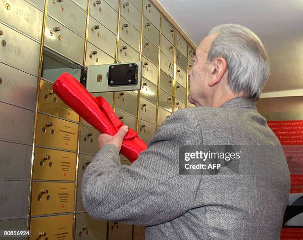 Argentinian poet Juan Gelman, winner of Spain's prestigious Cervantes literary prize puts a parchment in a strong box in the Cervantes institute in...