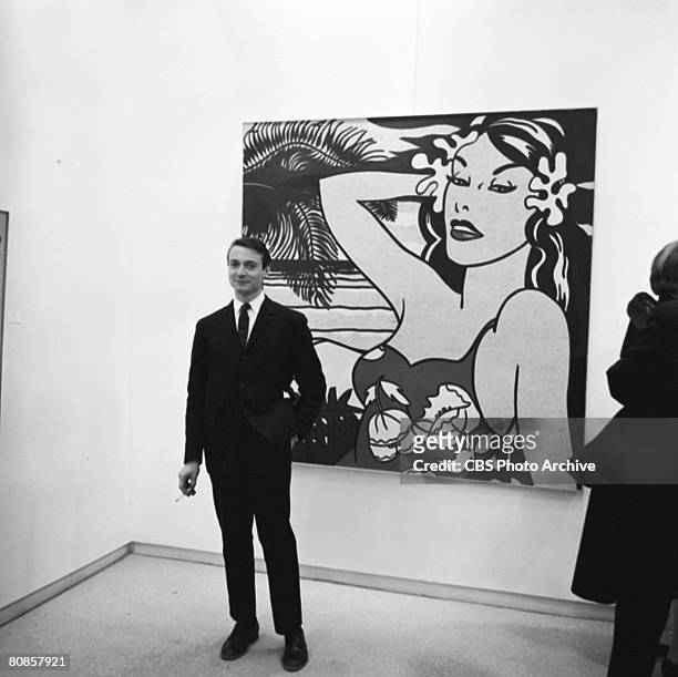 On an episode of the television documentary news program 'Eye on New York,' American artist Roy Lichtenstein poses in front of an unidentified...